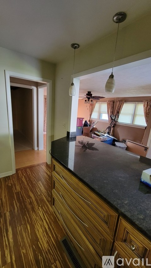 A kitchen with wooden cabinets and a black countertop.