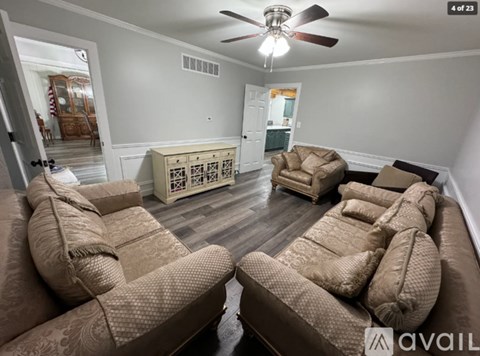 A living room with two couches and a ceiling fan.
