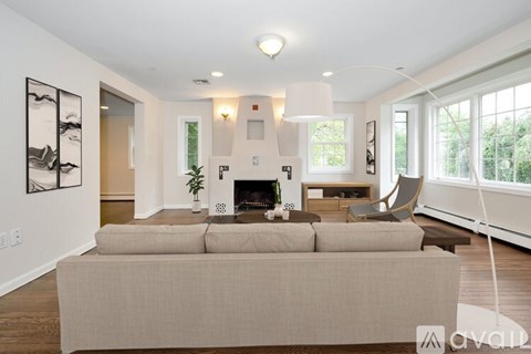A living room with a beige couch and a fireplace.