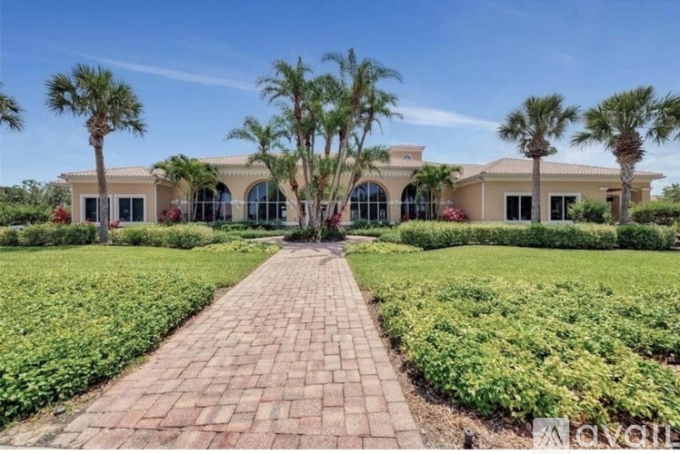 A large house with a brick pathway leading to it.