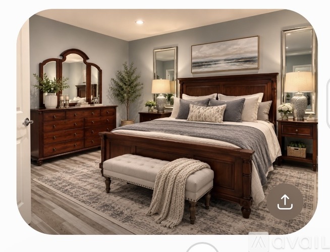 A bedroom with a large bed, a bench, and a dresser with a mirror.