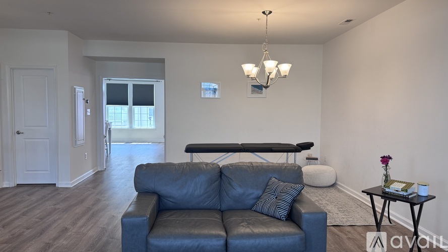 A living room with a blue couch and a chandelier.