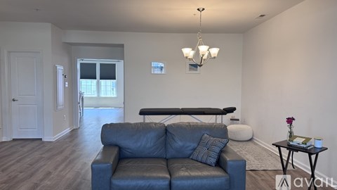 A living room with a blue couch and a chandelier.