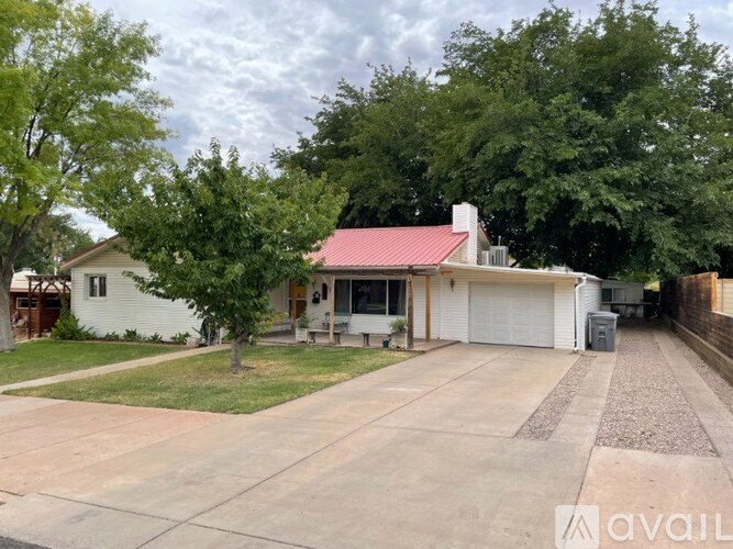 A house with a red roof and a garage is available for sale.