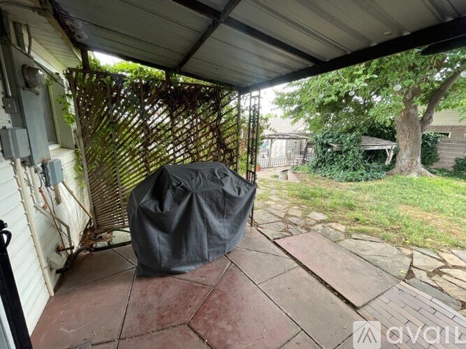 A black tarp is sitting on a patio under a covered area.