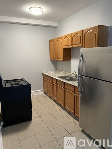 A kitchen with wooden cabinets and a stainless steel refrigerator.