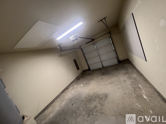 A room with a garage door and a light on the ceiling.