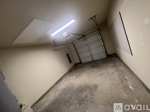 A room with a garage door and a light on the ceiling.