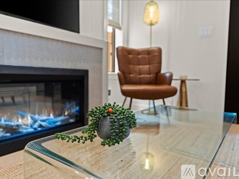 A brown leather chair sits in front of a fireplace in a modern living room.
