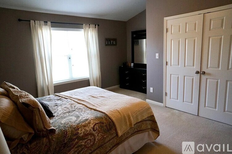 A bedroom with a bed, dresser, and mirror.