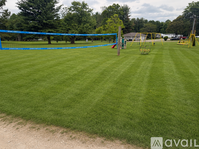A grassy field with a blue net and yellow goalposts.