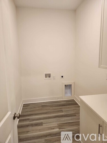 A room with a wooden floor and a white wall.