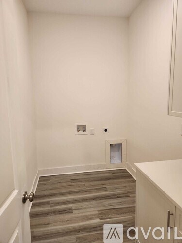A room with a wooden floor and a white wall.