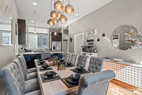 A modern dining room with a long table set for a meal.