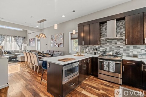 A modern kitchen with dark wood cabinets and stainless steel appliances.