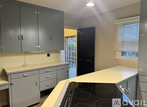 A kitchen with a stove top oven and cabinets.