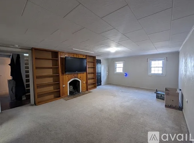 A spacious room with a fireplace and a television built into the wall.