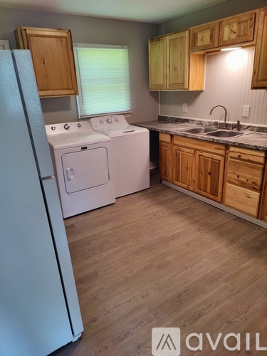 A kitchen with wooden cabinets and a white fridge.