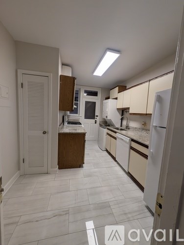 A kitchen with white cabinets and a white refrigerator.
