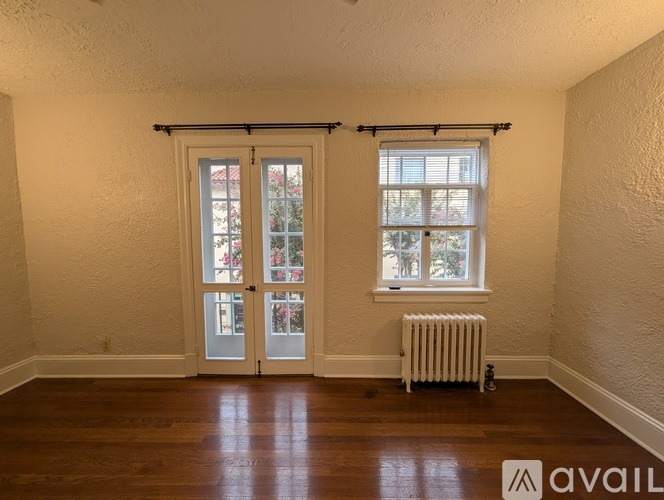 A room with a sliding door, a window, and a radiator.