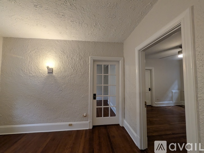 A room with a white wall and a wooden floor.