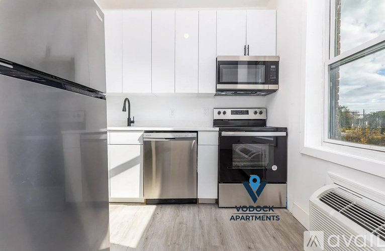 A kitchen with a stainless steel refrigerator, microwave, oven, and dishwasher.
