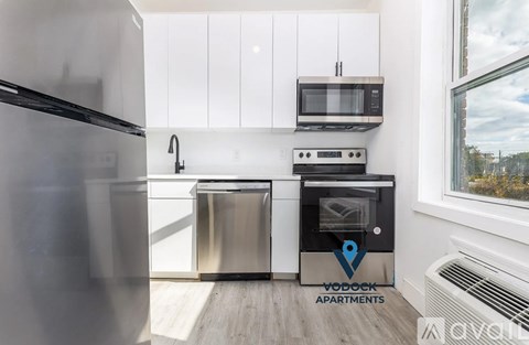 A kitchen with a stainless steel refrigerator, microwave, oven, and dishwasher.