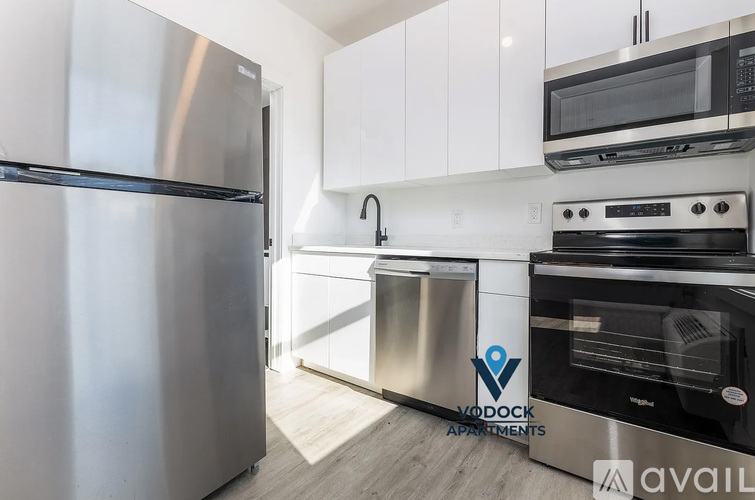 A modern kitchen with stainless steel appliances and white cabinets.