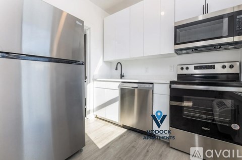 A modern kitchen with stainless steel appliances and white cabinets.