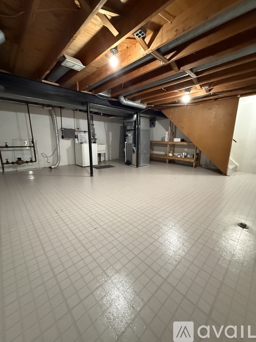 A spacious room with a tiled floor and wooden ceiling.