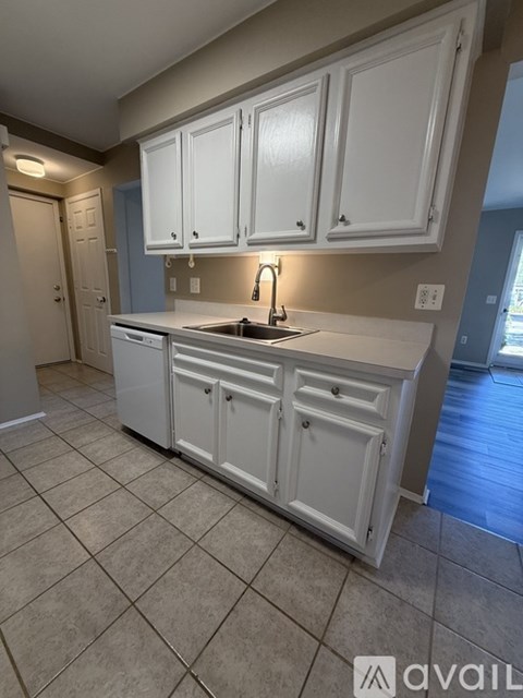 A kitchen with white cabinets and a sink.