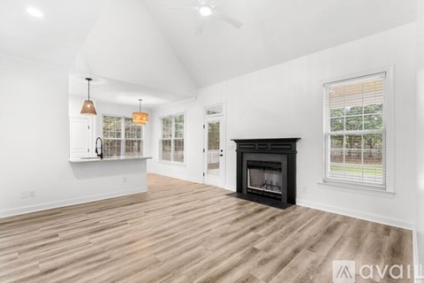 A spacious living room with a fireplace and hardwood floors.