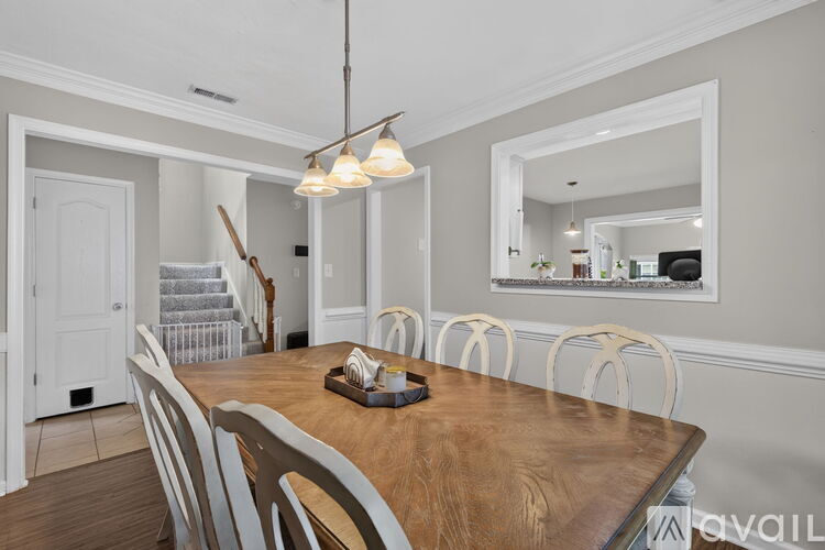 A dining room with a wooden table and chairs.