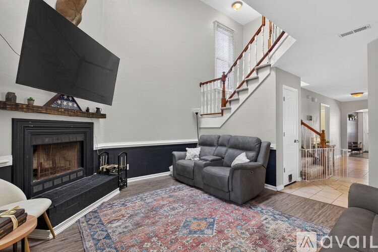 A living room with a grey couch and a fireplace.