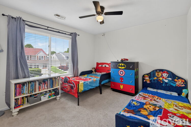 A bedroom with two beds and a bookshelf.