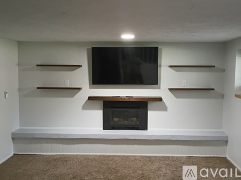 A living room with a fireplace and a flat screen TV mounted on the wall.
