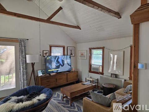 A living room with a blue chair and a wooden cabinet.
