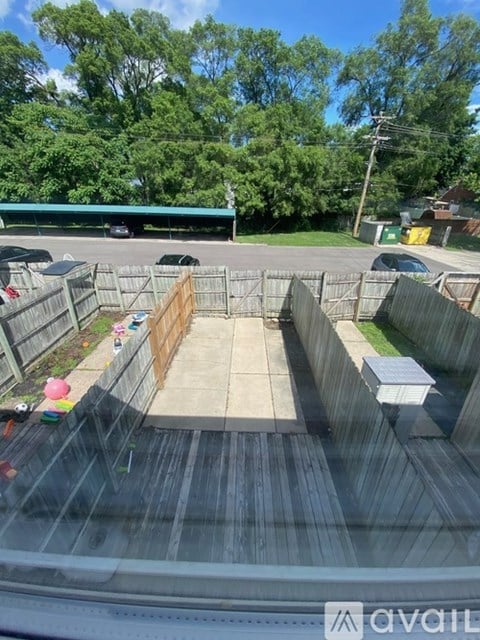 A view from inside a vehicle looking out onto a parking lot with a green building in the background.