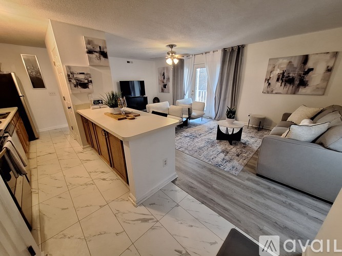 A living room with a kitchen area in the background.