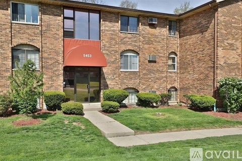 A brick building with the number 5453 on the awning.