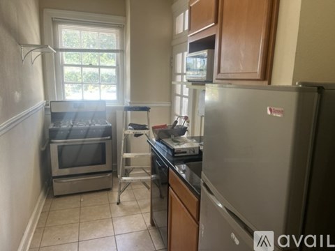 A kitchen with a refrigerator, oven, and microwave.