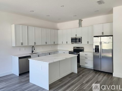 A kitchen with white cabinets and a wooden floor.