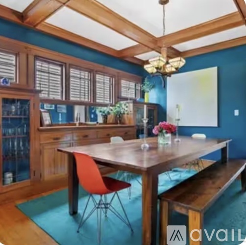 A dining room with a wooden table and chairs.