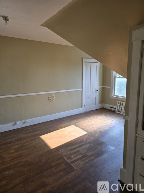 A room with wooden floors and a white door.