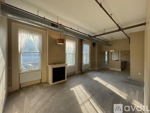 A spacious room with a fireplace and large windows.