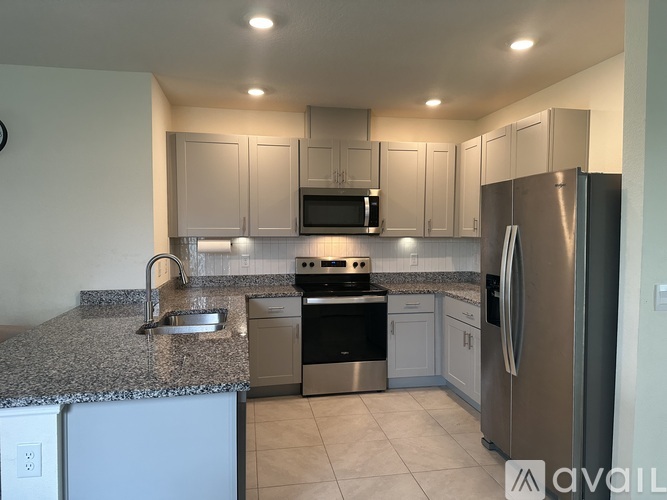 A kitchen with granite countertops and stainless steel appliances.