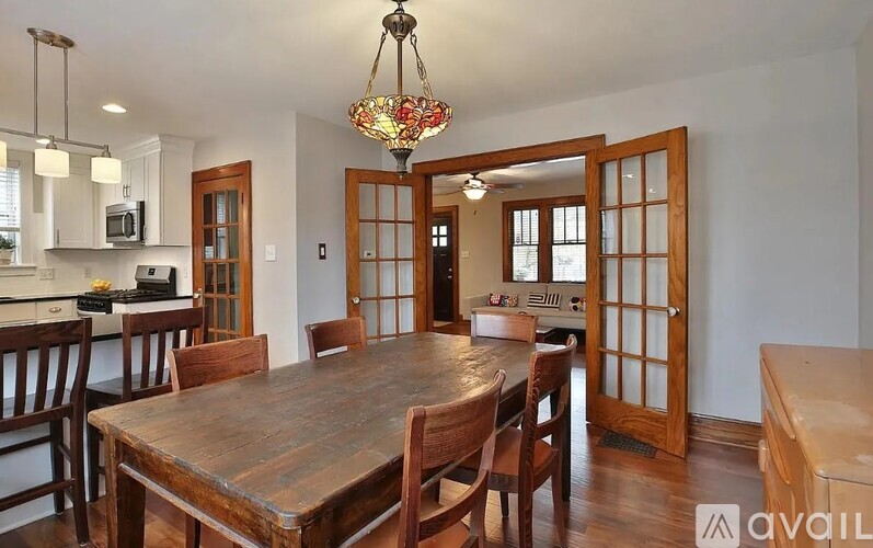 A dining room with a wooden table and chairs.