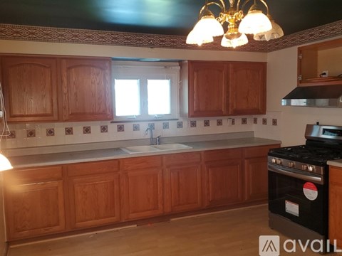 A kitchen with wooden cabinets and a black stove top oven.