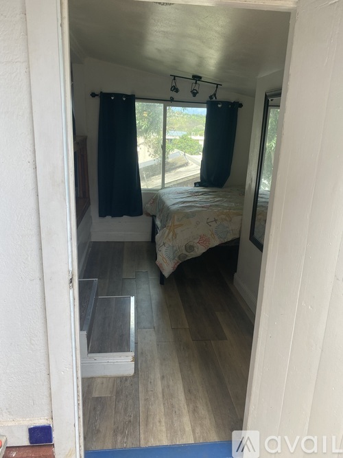 A room with a bed and a window with curtains.