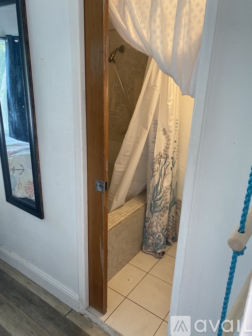 A white door with a curtain and a rope on the right side.